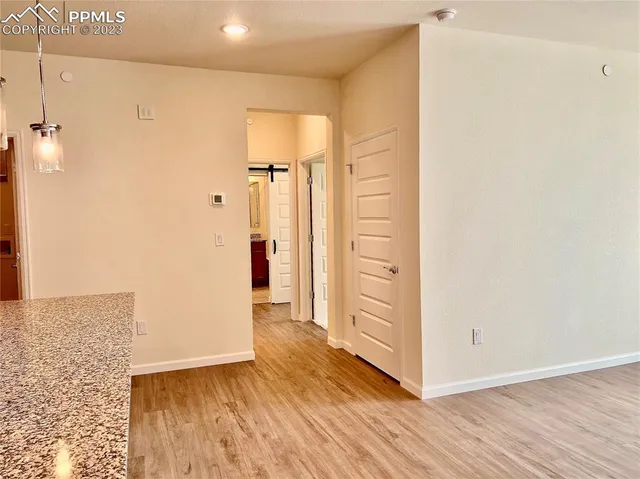 a view of a hallway with wooden floor and a bathroom
