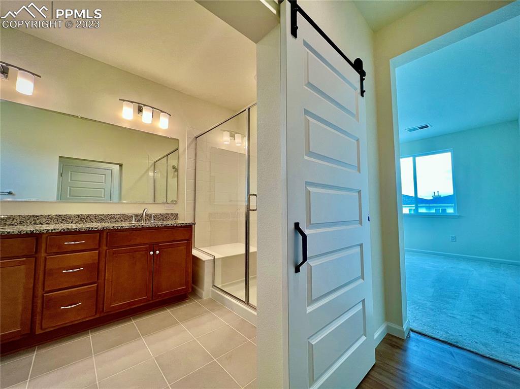 3865 Presidio Point, Unit 202 Colorado Springs, CO 80920 - Photo 10 of 30 a bathroom with a granite countertop sink mirror and a bathtub