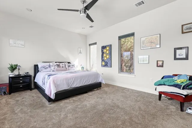 a bedroom with a bed dresser and window