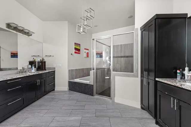 a bathroom with a sink vanity granite tub and shower