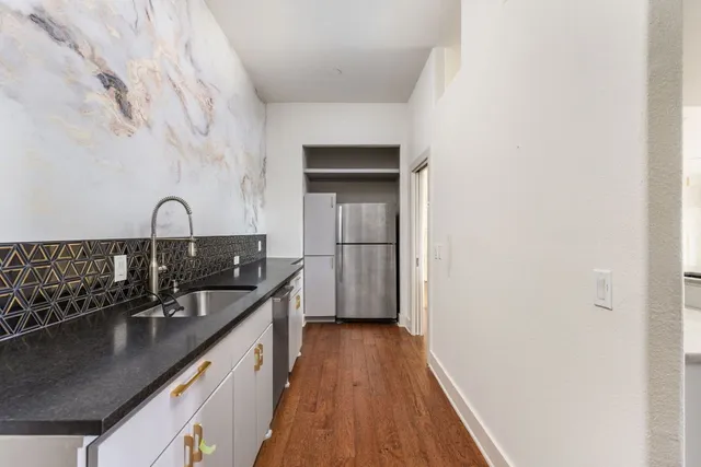 a kitchen with a sink a counter top space and cabinets