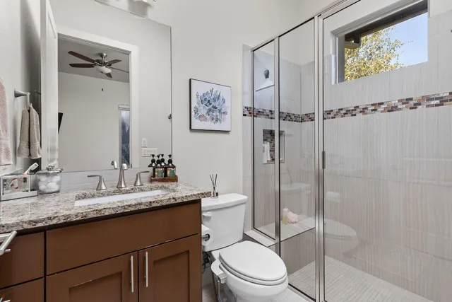 a bathroom with a granite countertop sink toilet and shower