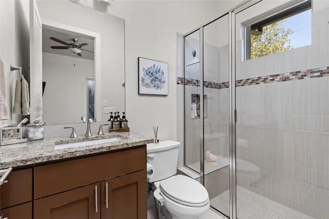 a bathroom with a granite countertop sink toilet and shower