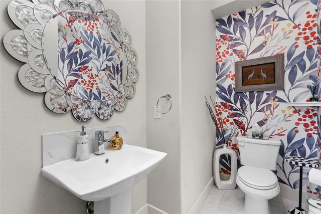 a bathroom with a toilet sink and mirror