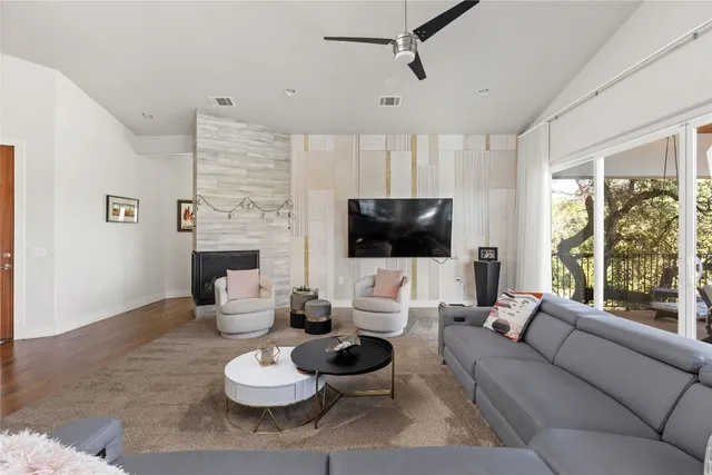 a living room with furniture a flat screen tv and a large window