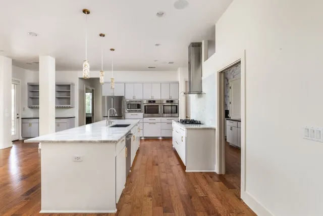 a kitchen with kitchen island a counter top space a sink and appliances