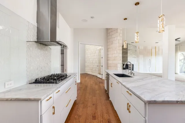 a kitchen with granite countertop a sink stove and cabinets