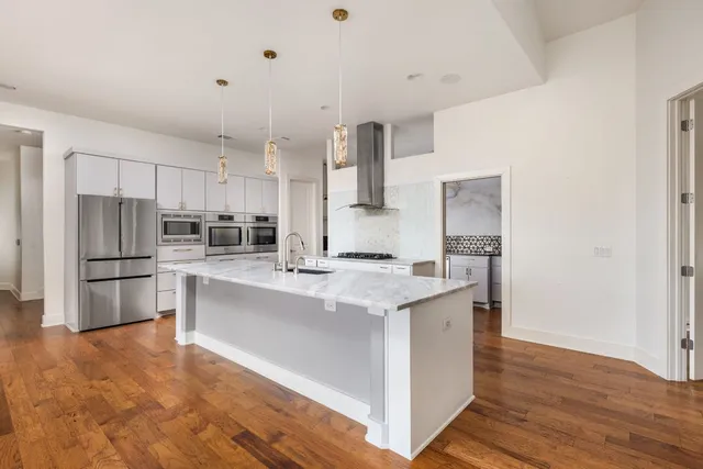 a kitchen with stainless steel appliances a refrigerator and a stove top oven