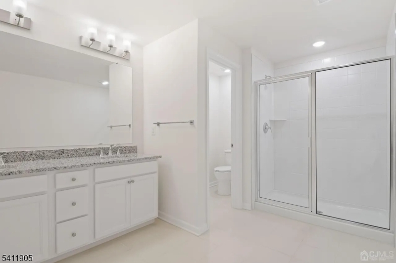 735 Station Road Dunellen, NJ 08812 - Photo 12 of 36 a bathroom with a granite countertop sink two mirror and a shower
