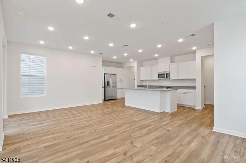 735 Station Road Dunellen, NJ 08812 - Photo 4 of 36 a large kitchen with kitchen island a sink wooden floor white stainless steel appliances and cabinets
