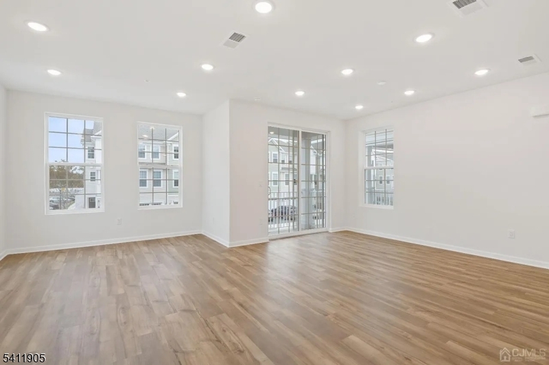 735 Station Road Dunellen, NJ 08812 - Photo 6 of 36 a view of an empty room with wooden floor and a window