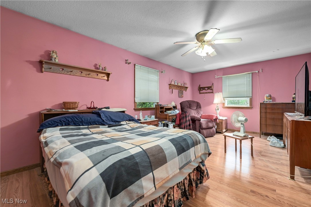 1140 West River Road Vermilion, OH 44089 - Photo 21 of 49 Bedroom with a textured ceiling, wood finished floors, and ceiling fan