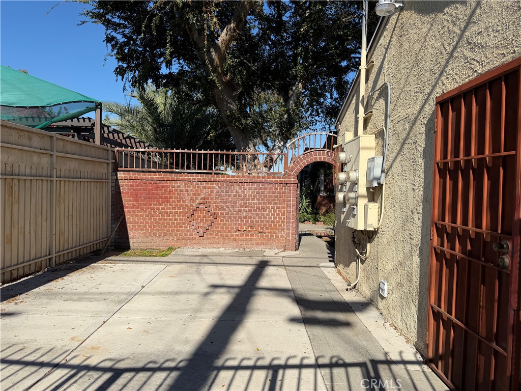 338 West Magnolia Street Compton, CA 90220 - Photo 4 of 5 a view of a patio with couches and table and chairs under an umbrella with wooden fence