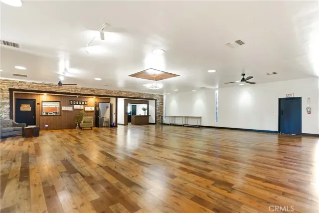 an empty room with wooden floor and chandelier