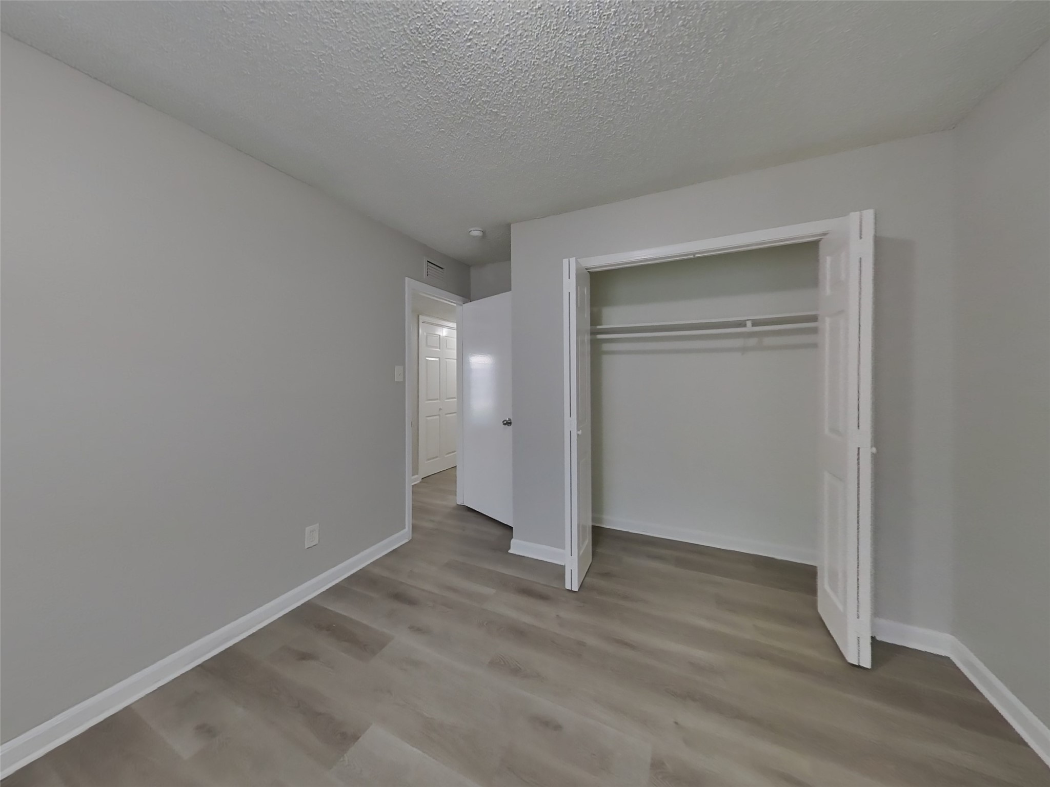 623 Walston Lane Houston, TX 77060 - Photo 14 of 21 a view of an empty room with wooden floor & closet area