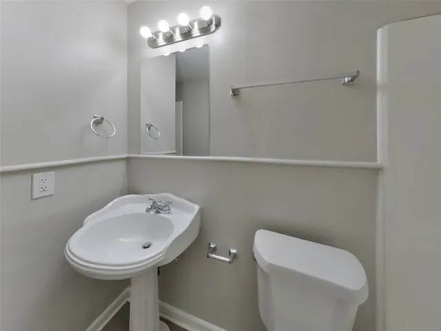 a bathroom with a toilet a sink and mirror