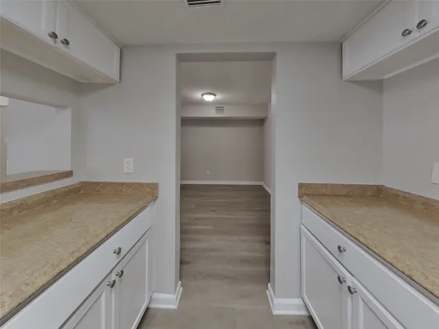 a kitchen with granite countertop white cabinets and a sink