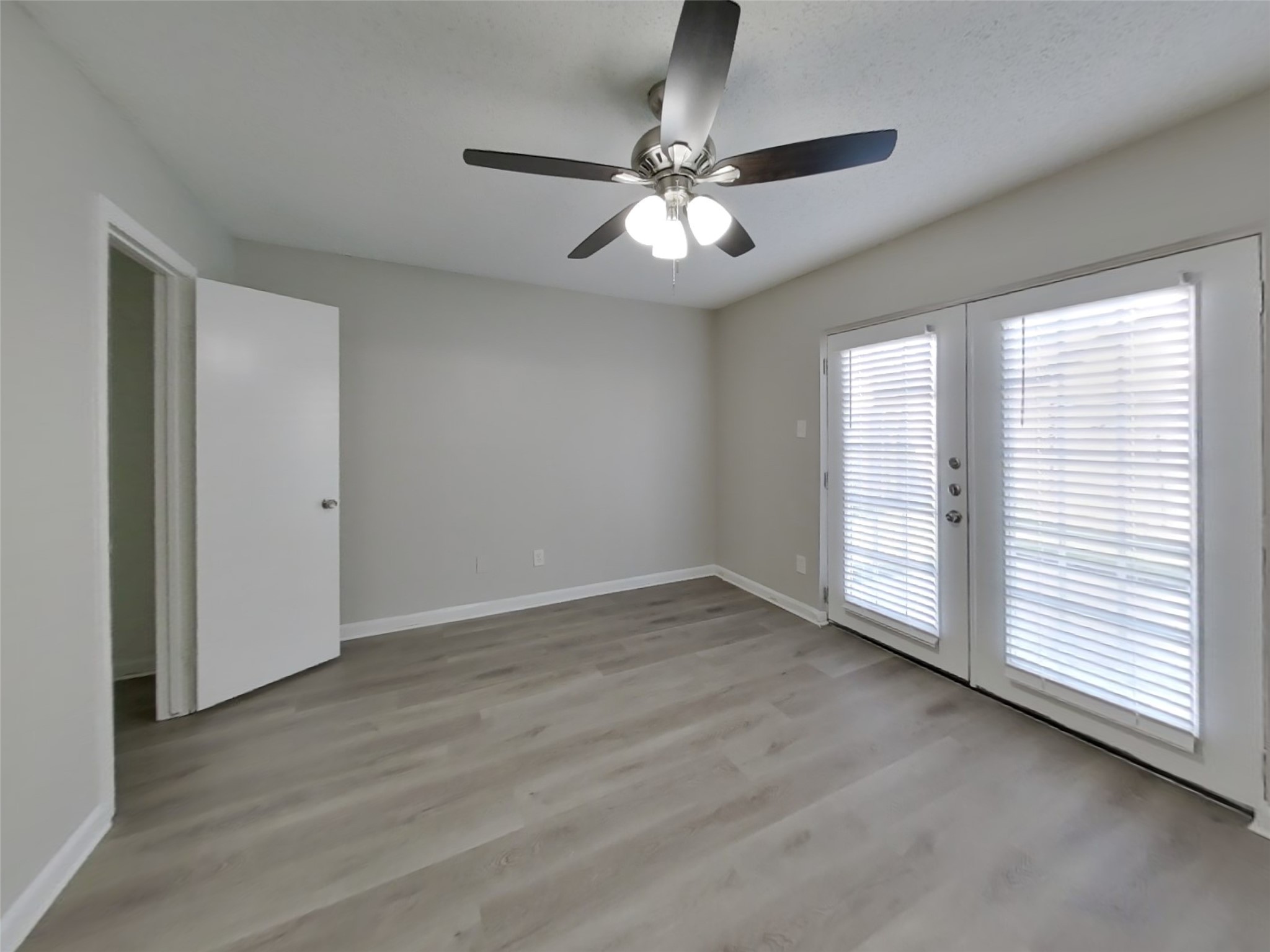 623 Walston Lane Houston, TX 77060 - Photo 8 of 21 an empty room with wooden floor fan and windows