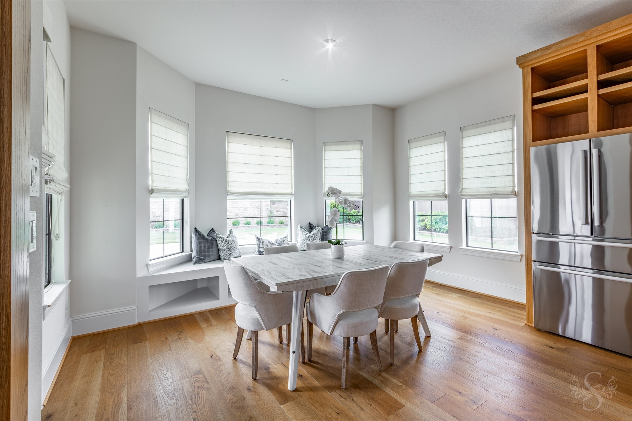 27919 Indigo Ridge Drive Fulshear, TX 77441 - Photo 22 of 50 The bright and airy breakfast room is encircled by a wall of windows, bathing the space in natural light and framing peaceful views of the backyard. A charming built-in window bench adds warmth and character, creating an inviting spot for casual meals, morning coffee, or cozy conversation.