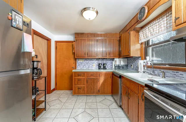 a kitchen with stainless steel appliances granite countertop a refrigerator and a sink
