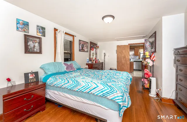 a bedroom with a bed and wooden floor