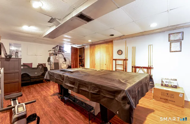 a living room with stainless steel appliances granite countertop lots of furniture and a wooden floors