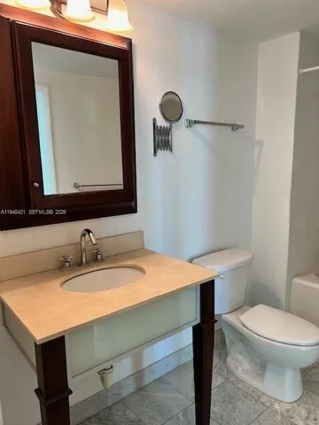 a bathroom with a sink a toilet and mirror