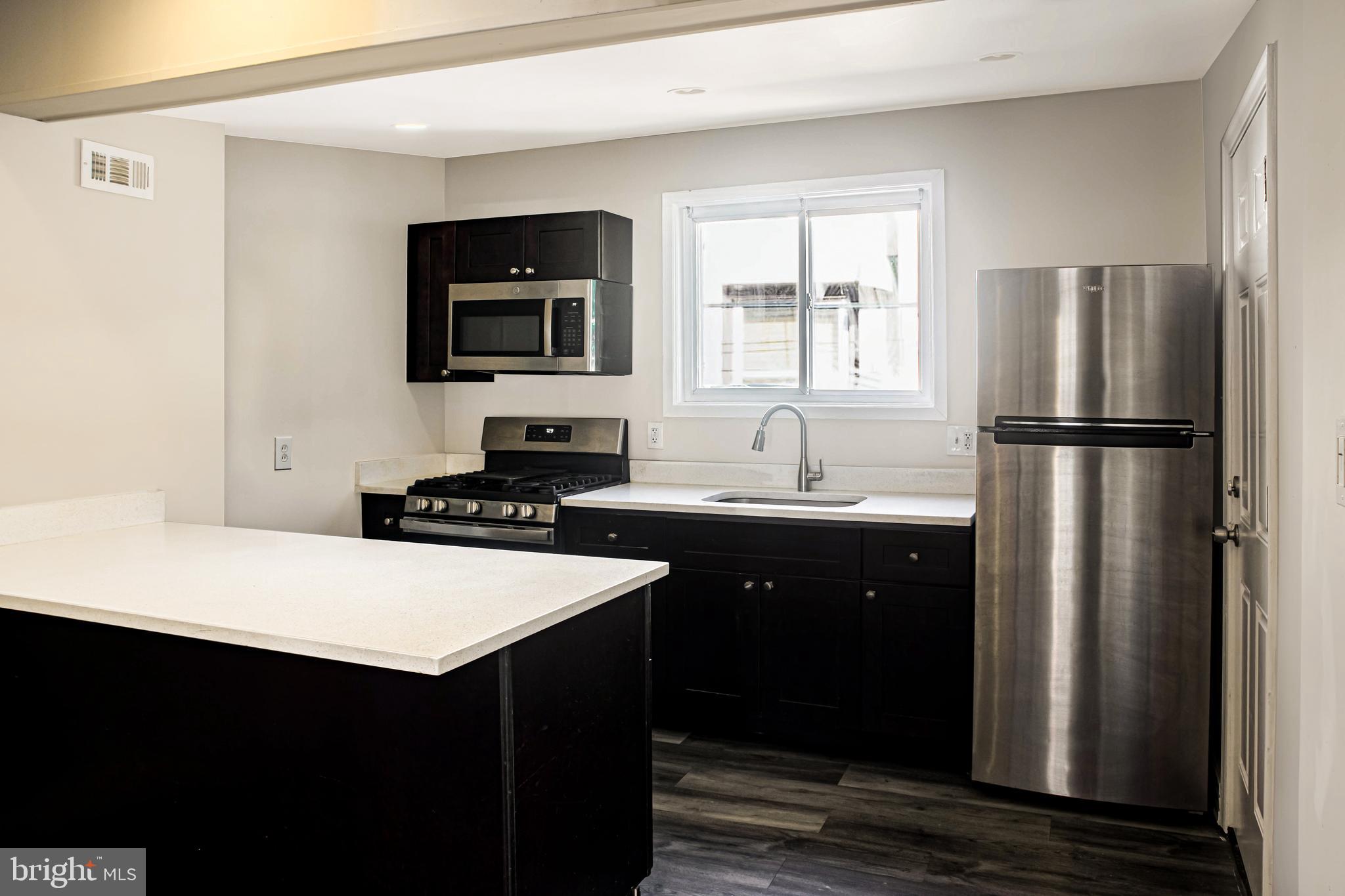 2137 Mifflin Street Philadelphia, PA 19145 - Photo 6 of 21 a kitchen with a sink a refrigerator and white cabinets