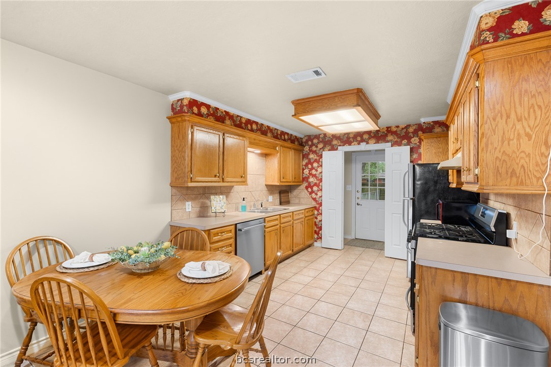 2287 North Earl Rudder Freeway Bryan, TX 77803 - Photo 21 of 32 a kitchen with stainless steel appliances kitchen island granite countertop a sink and cabinets