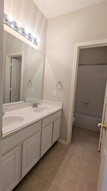 20909 Springport Court Katy, TX 77450 - Photo 28 of 39 Bright bathroom featuring a double vanity with ample cabinet storage, a large mirror with modern lighting, and a tub-shower combo in a clean, tiled space.