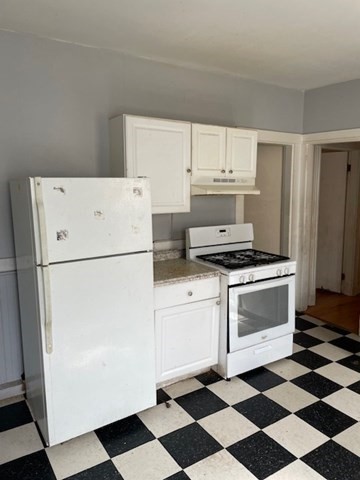 25 Wolcott Street Boston, MA 02121 - Photo 3 of 14 a kitchen with a refrigerator and white cabinets
