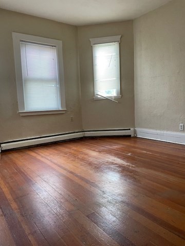 25 Wolcott Street Boston, MA 02121 - Photo 6 of 14 an empty room with wooden floor and windows