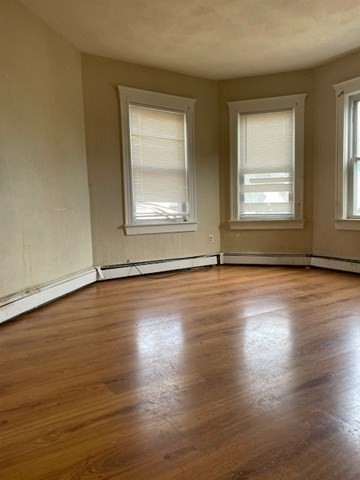 25 Wolcott Street Boston, MA 02121 - Photo 7 of 14 an empty room with wooden floor and windows