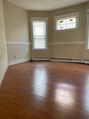 25 Wolcott Street Boston, MA 02121 - Photo 9 of 14 an empty room with wooden floor and windows