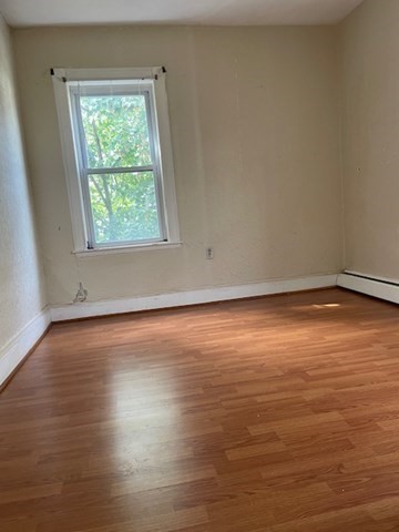 25 Wolcott Street Boston, MA 02121 - Photo 10 of 14 an empty room with wooden floor and windows