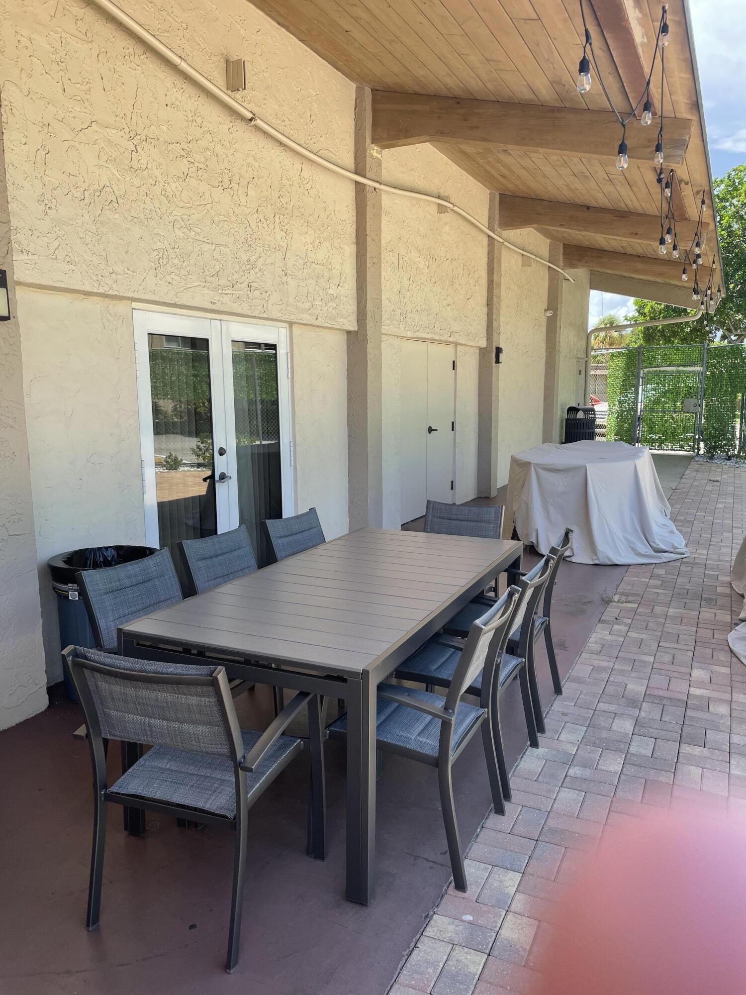 725 Lori Drive, Unit 406 Palm Springs, FL 33461 - Photo 23 of 40 a view of a patio with table and chairs