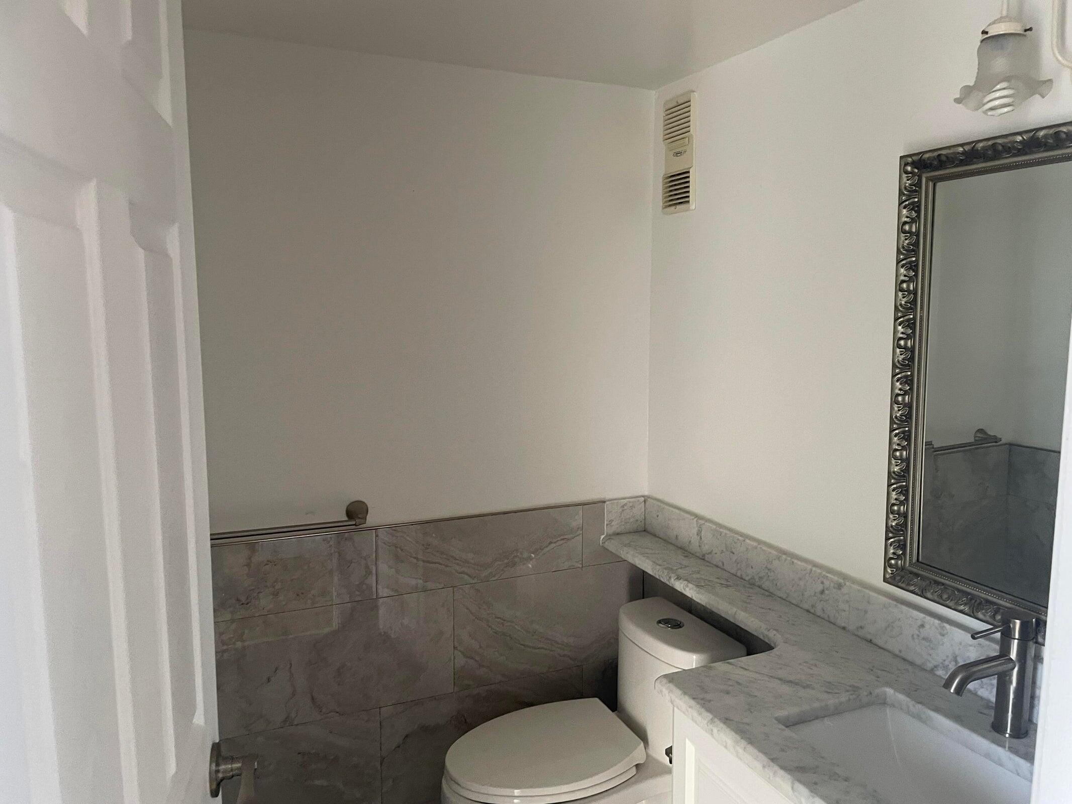 725 Lori Drive, Unit 406 Palm Springs, FL 33461 - Photo 40 of 40 a bathroom with a toilet sink and shower