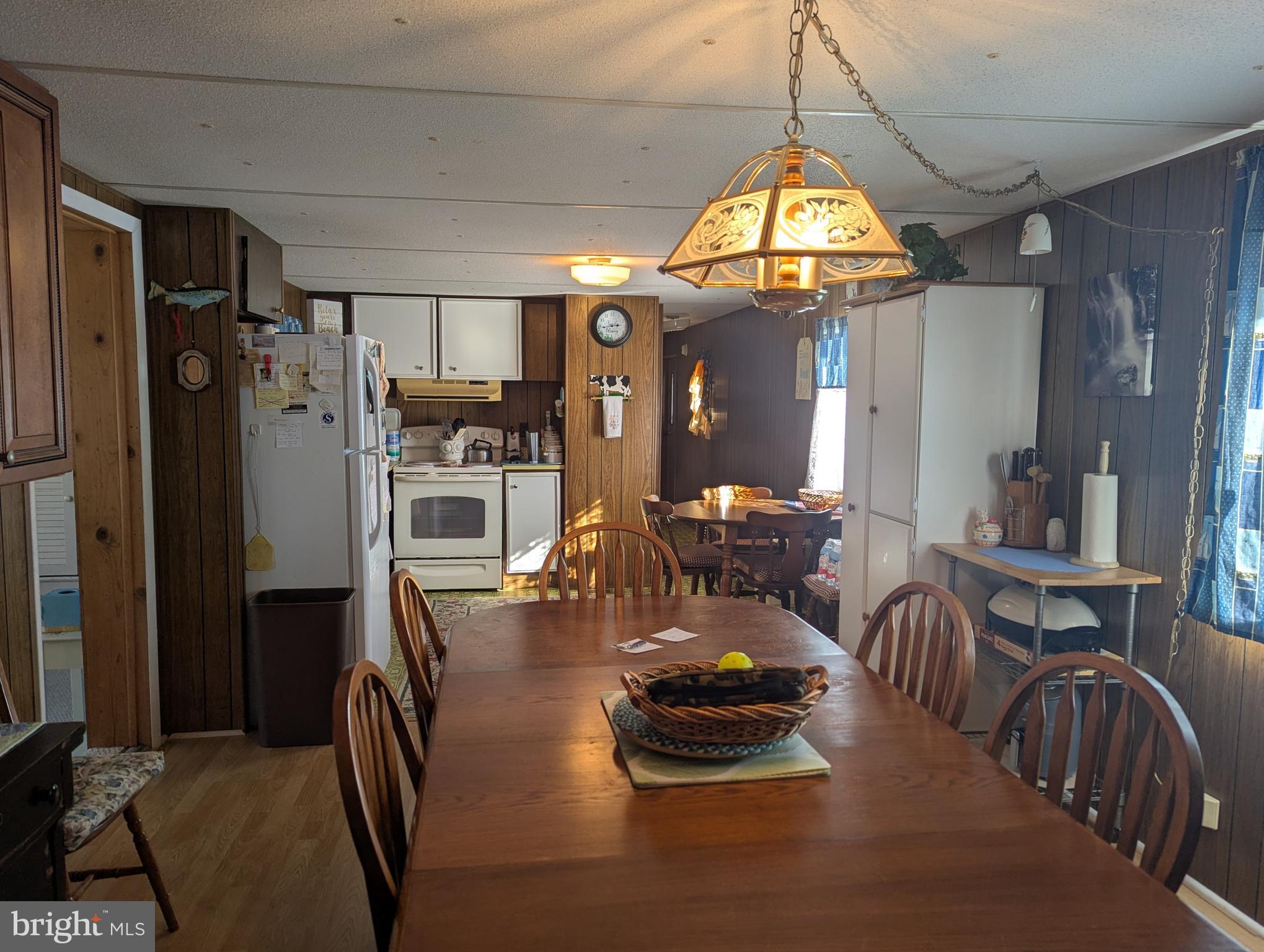 33501 Grape Street Millsboro, DE 19966 - Photo 12 of 38 a view of a dining room with furniture a chandelier and wooden floor