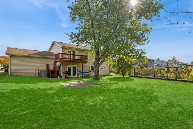 a view of a house with a big yard potted plants and large tree