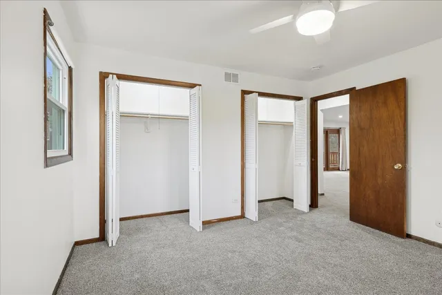 a view of an empty room with closet and a bathroom