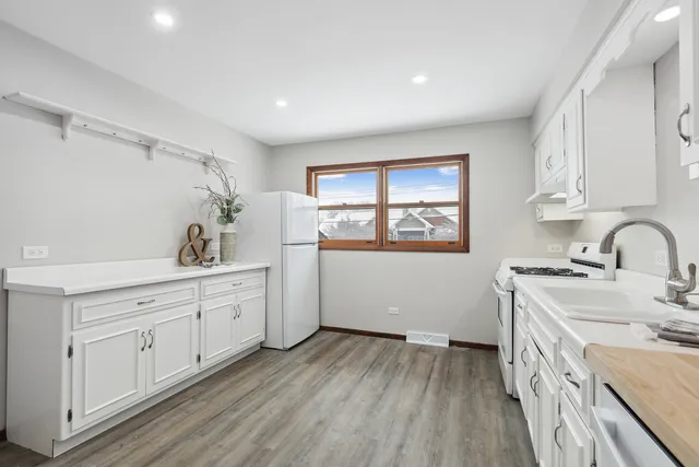 a view of a kitchen with sink and dishwasher with wooden floor