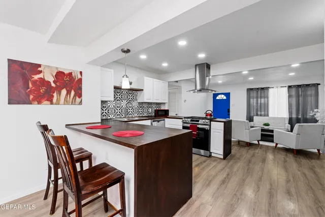a kitchen with kitchen island a stove a table and a refrigerator