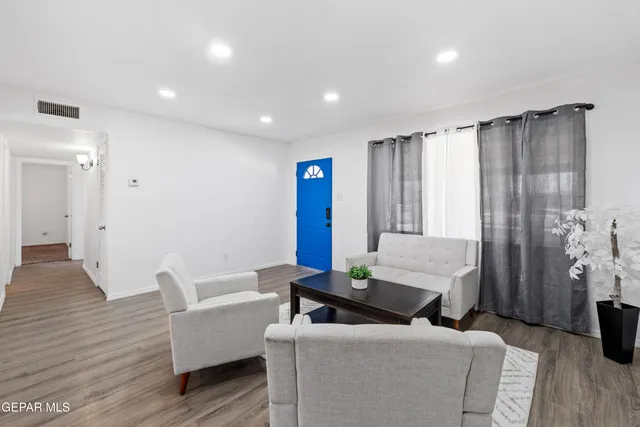 a living room with furniture and a wooden floor