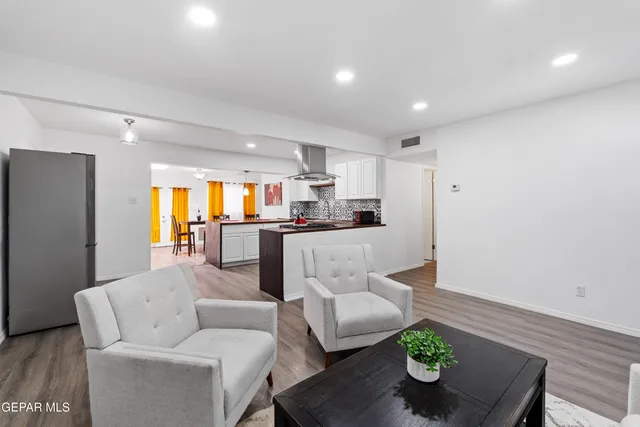 a living room with furniture and kitchen view