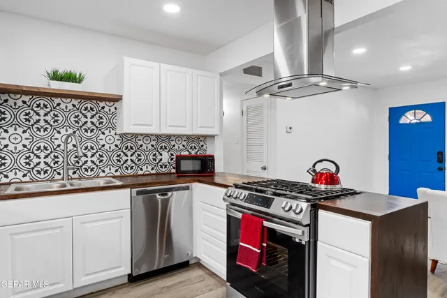 a kitchen with stainless steel appliances granite countertop a stove a sink and a refrigerator