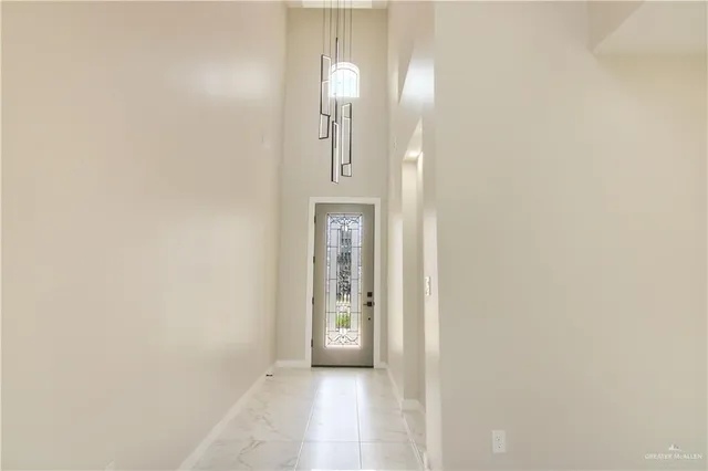 a view of a hallway with wooden floor and a bathroom
