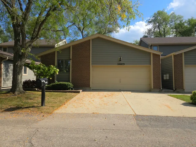 a front view of a house with a yard and a garage