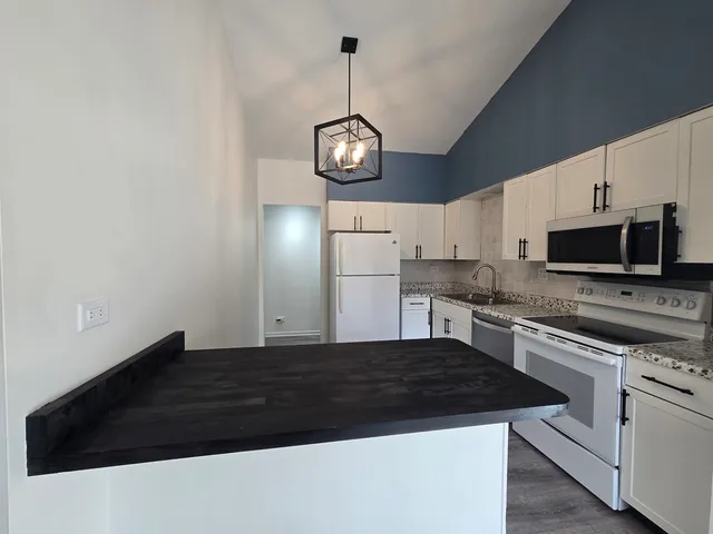 a kitchen with stainless steel appliances granite countertop a sink a stove a microwave and cabinets