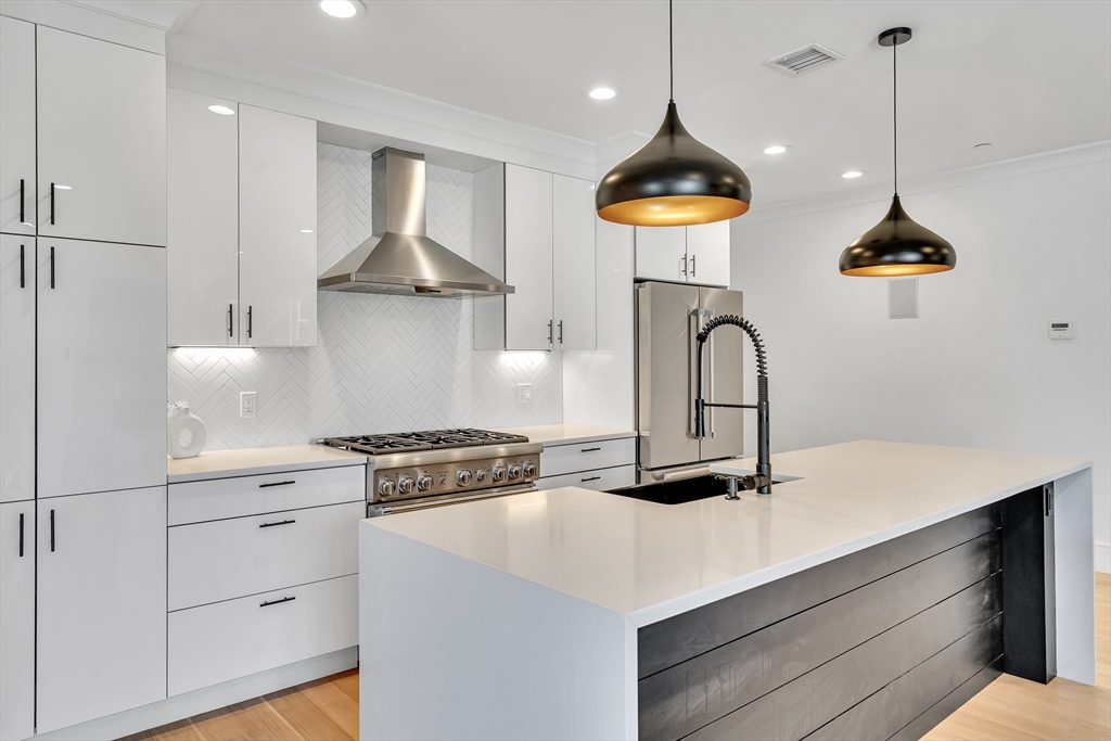 148 West 9th Street, Unit 6 Boston, MA 02127 - Photo 5 of 21 a kitchen with a stove and a chandelier