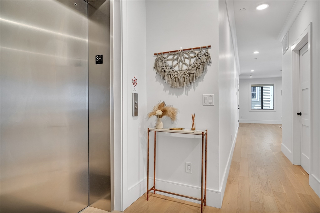 148 West 9th Street, Unit 6 Boston, MA 02127 - Photo 8 of 21 a view of a hallway with wooden floor and staircase
